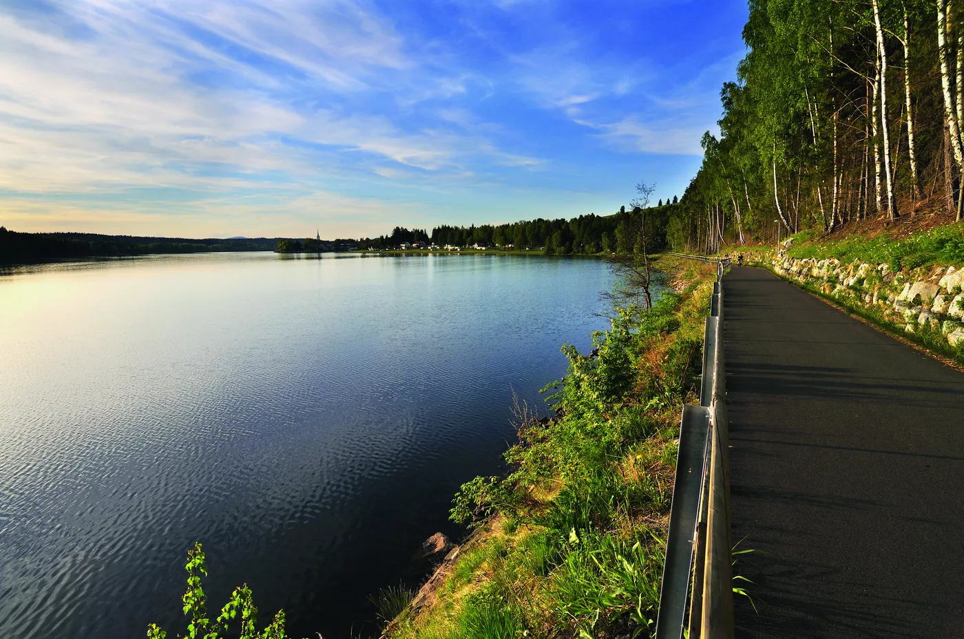 Straße am Ufer des Lipno-Stausees mit Blick über das Wasser Straße am Ufer des Lipno-Stausees mit Blick über das Wasser